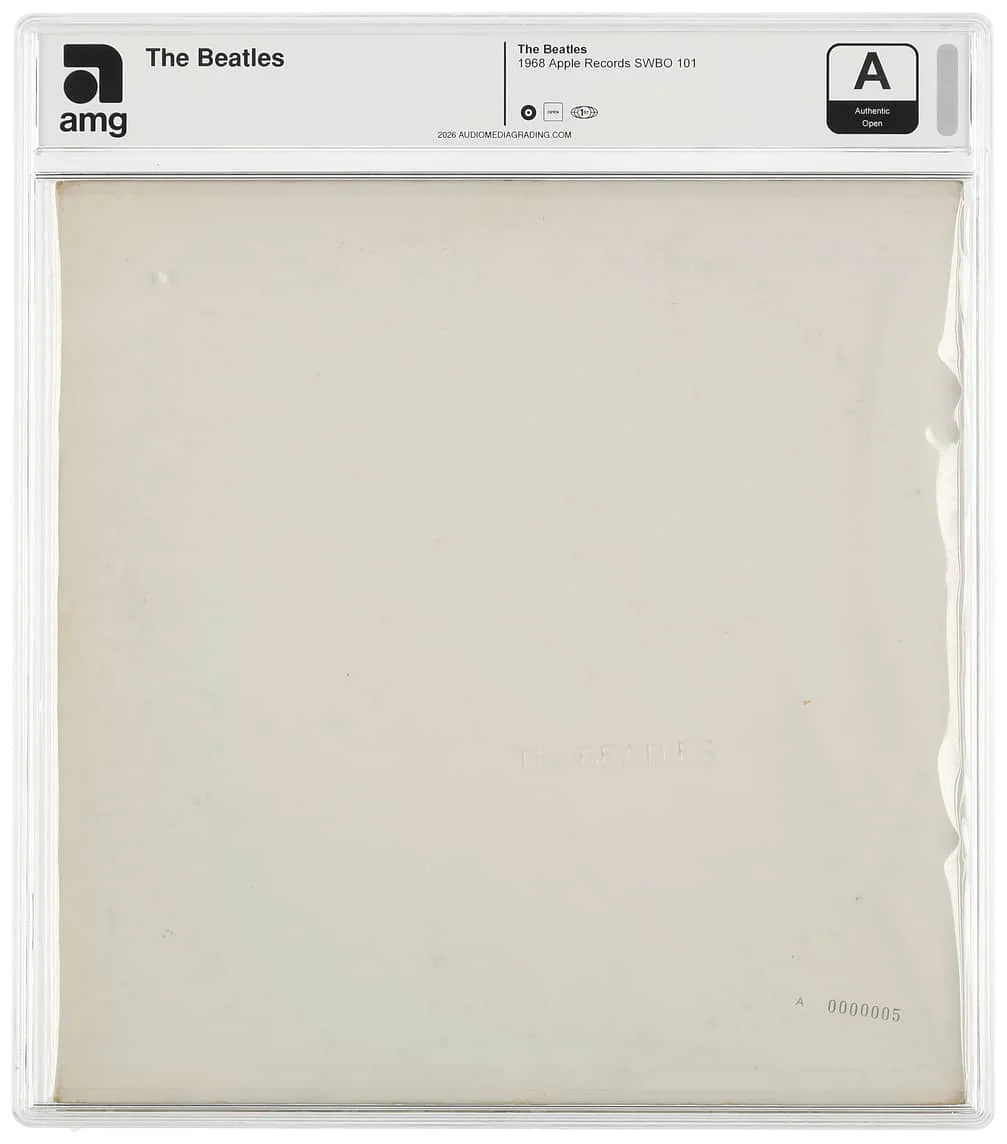 The image shows a framed and encased vinyl record album, "The Beatles," commonly known as "The White Album." The cover is minimalist and mostly white, featuring the band’s name embossed on the front. The record is labeled from 1968 by Apple Records.