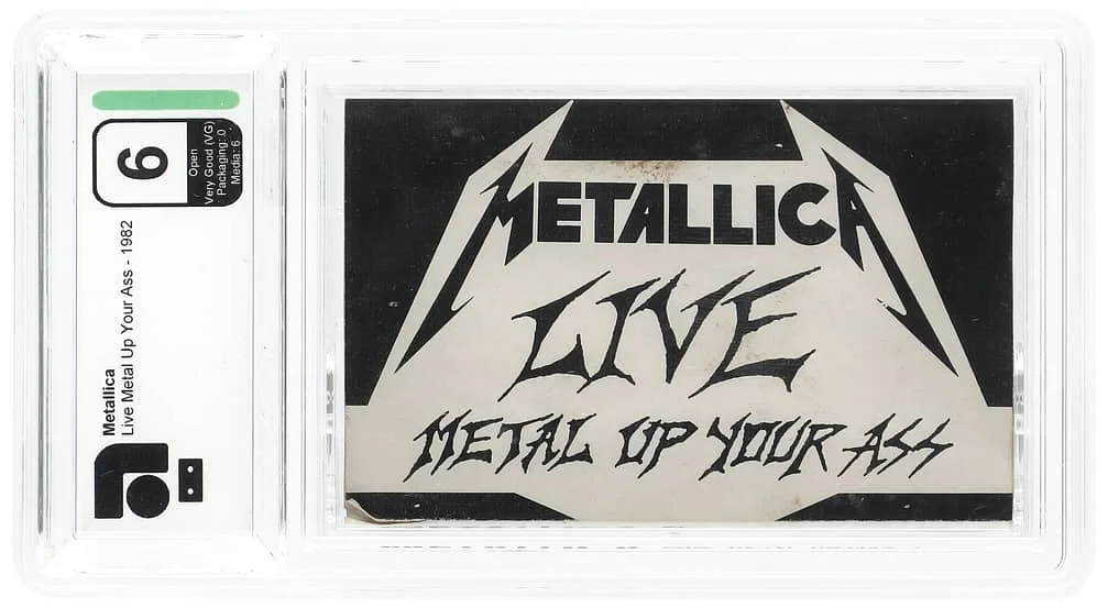 The image displays a PSA-graded ticket with a rating of 6 for a concert by the band Metallica. The ticket features the text "Metallica Live Metal Up Your Ass" and is encased in a clear protective holder.