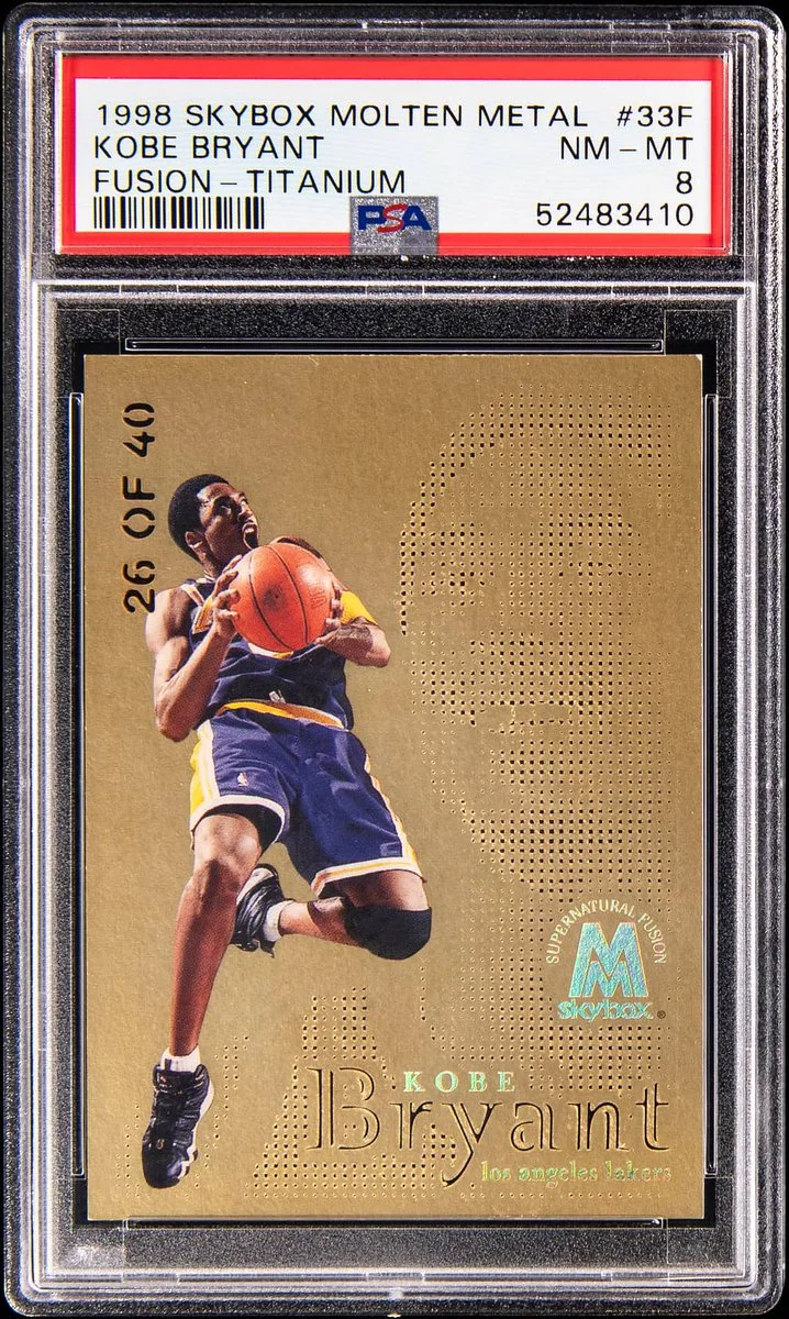 A 1998 Skybox Molten Metal basketball card featuring a player in a Los Angeles Lakers uniform holding a basketball. The card is labeled "Kobe Bryant" with "26 of 40." It is encased and graded "NM-MT 8" by PSA, with the number "52483410.