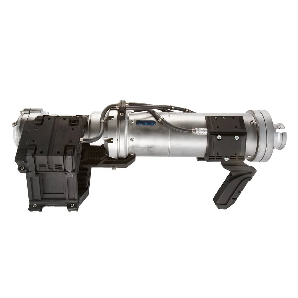 A silver Gatling-style flamethrower with a cylindrical body and multiple barrels. It features black handles and attachments, and the company name Proper on the side. The design appears industrial and functional.