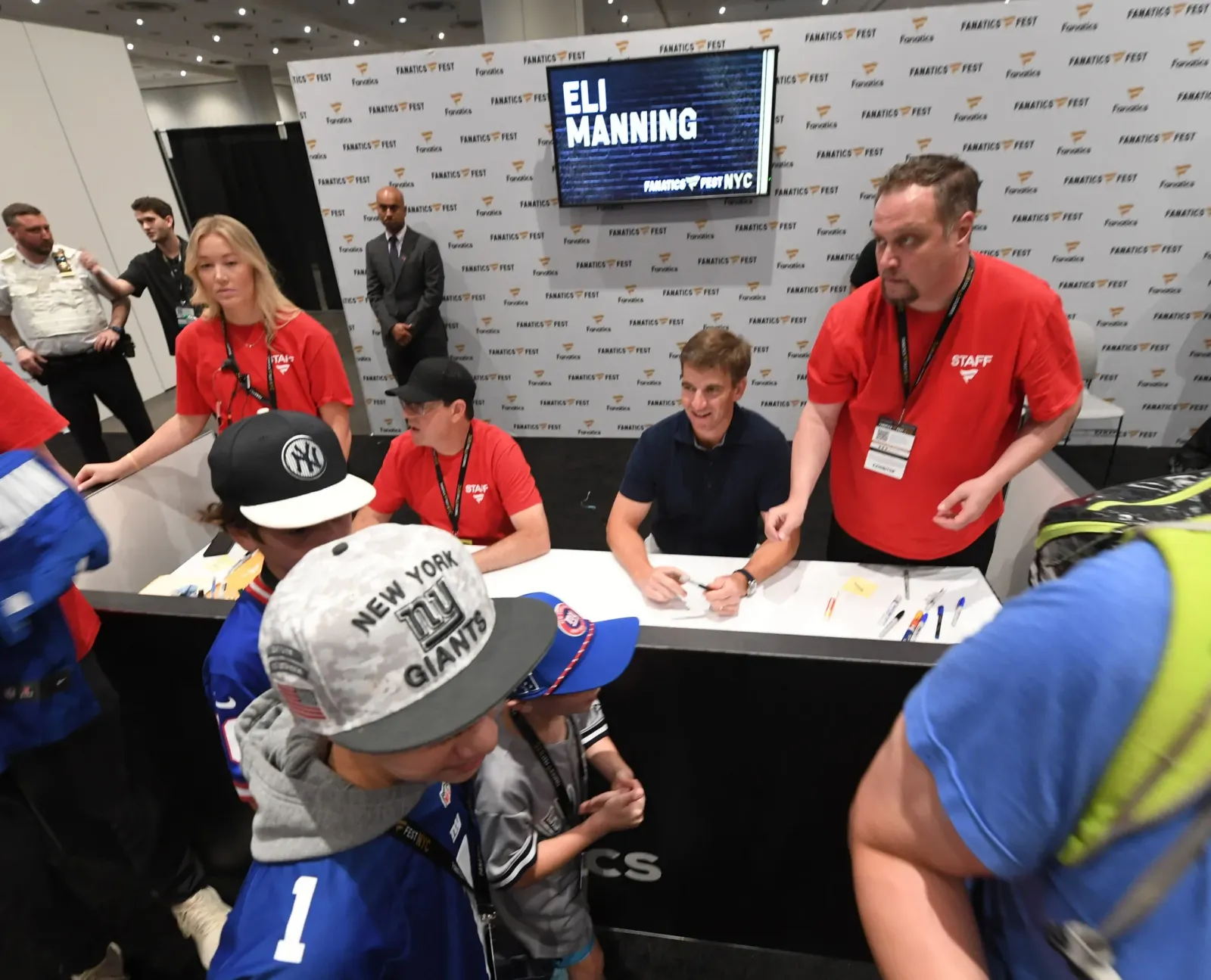 Former New York Giants star Eli Manning signs autographs for fans at Fanatics Fest NYC.