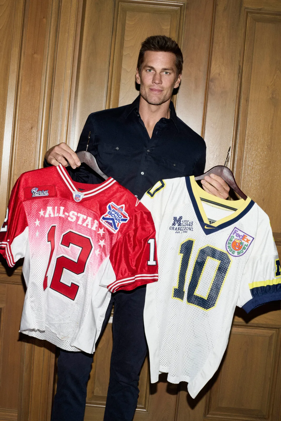 NFL legend Tom Brady shows of a collection of his game-worn college jerseys during a Sotheby's auction.