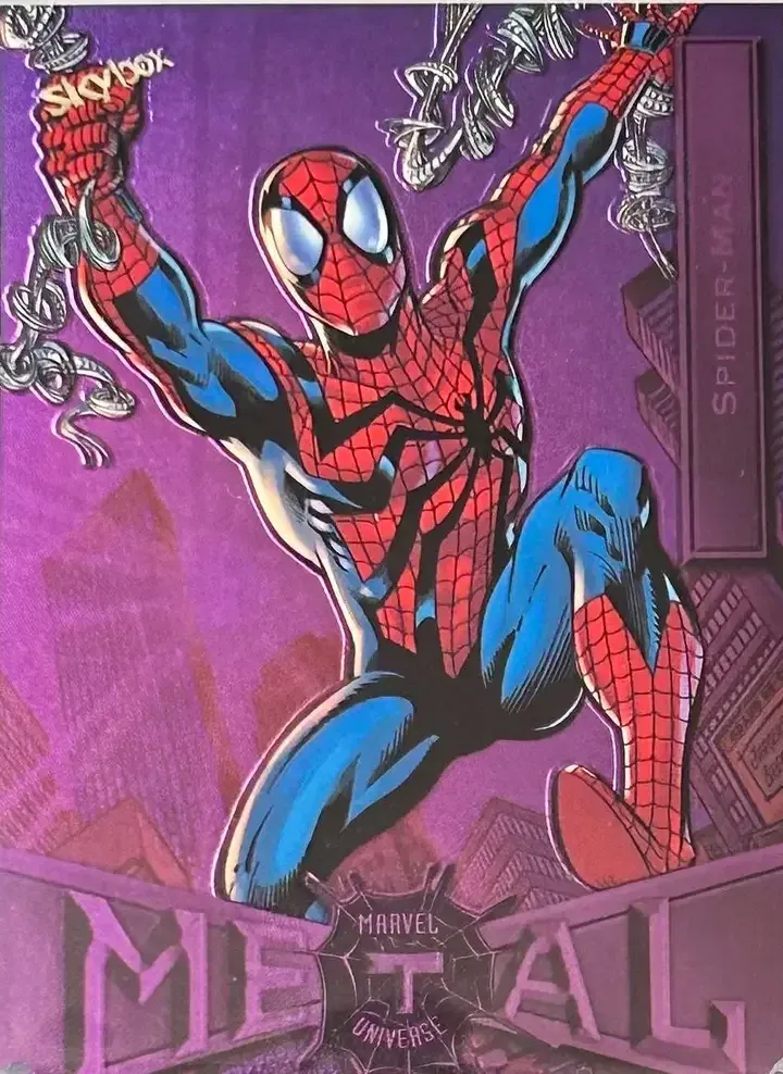 An image of a 2022 SkyBox Metal Universe Light Purple Spider-Man card with red and blue suit and web swinging with both hands