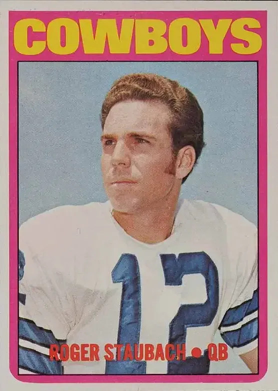 player on center of card, with white jersey, blue #12, and blue sky background, Cowboys in yellow on pink border.