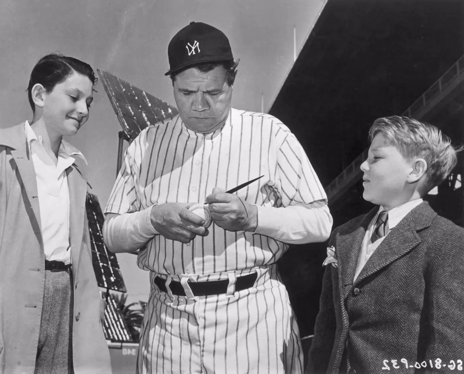 Babe Ruth signs autographs.